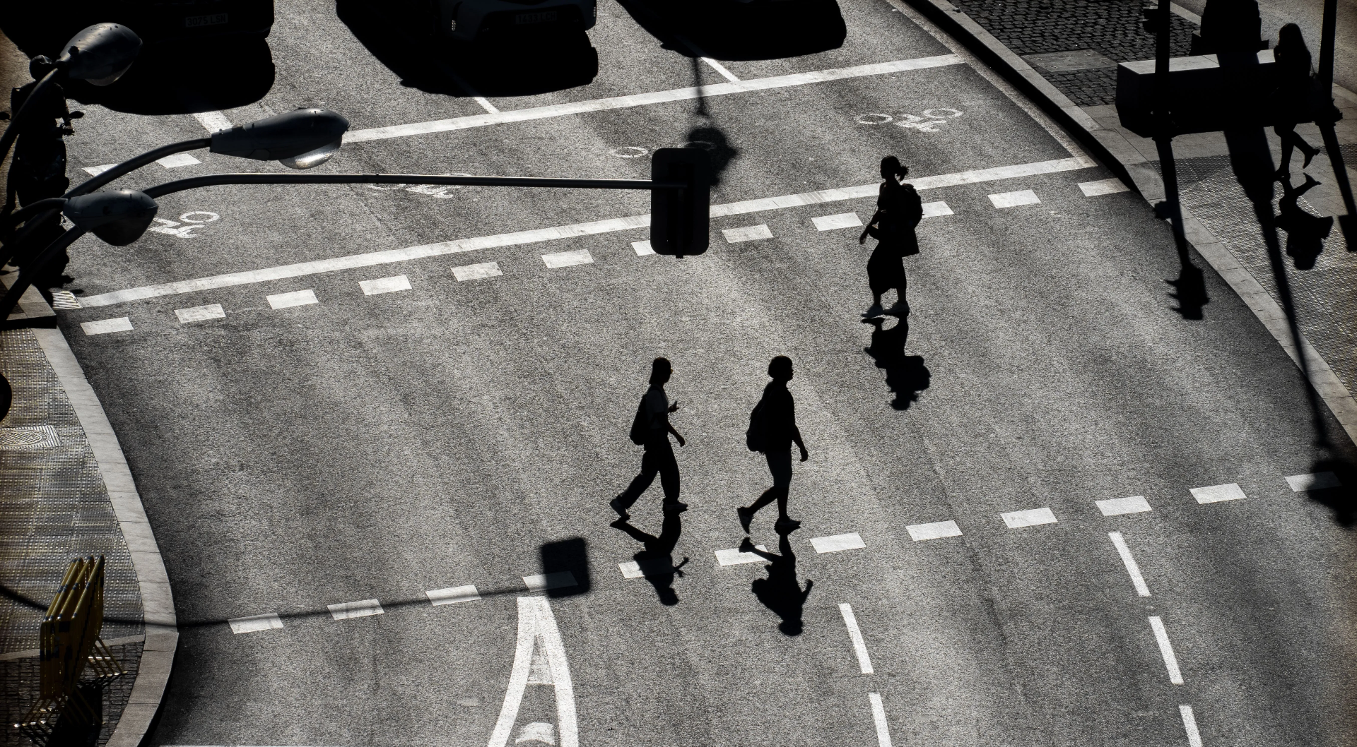Pedestrian silhouettes crossing a heat-baked street