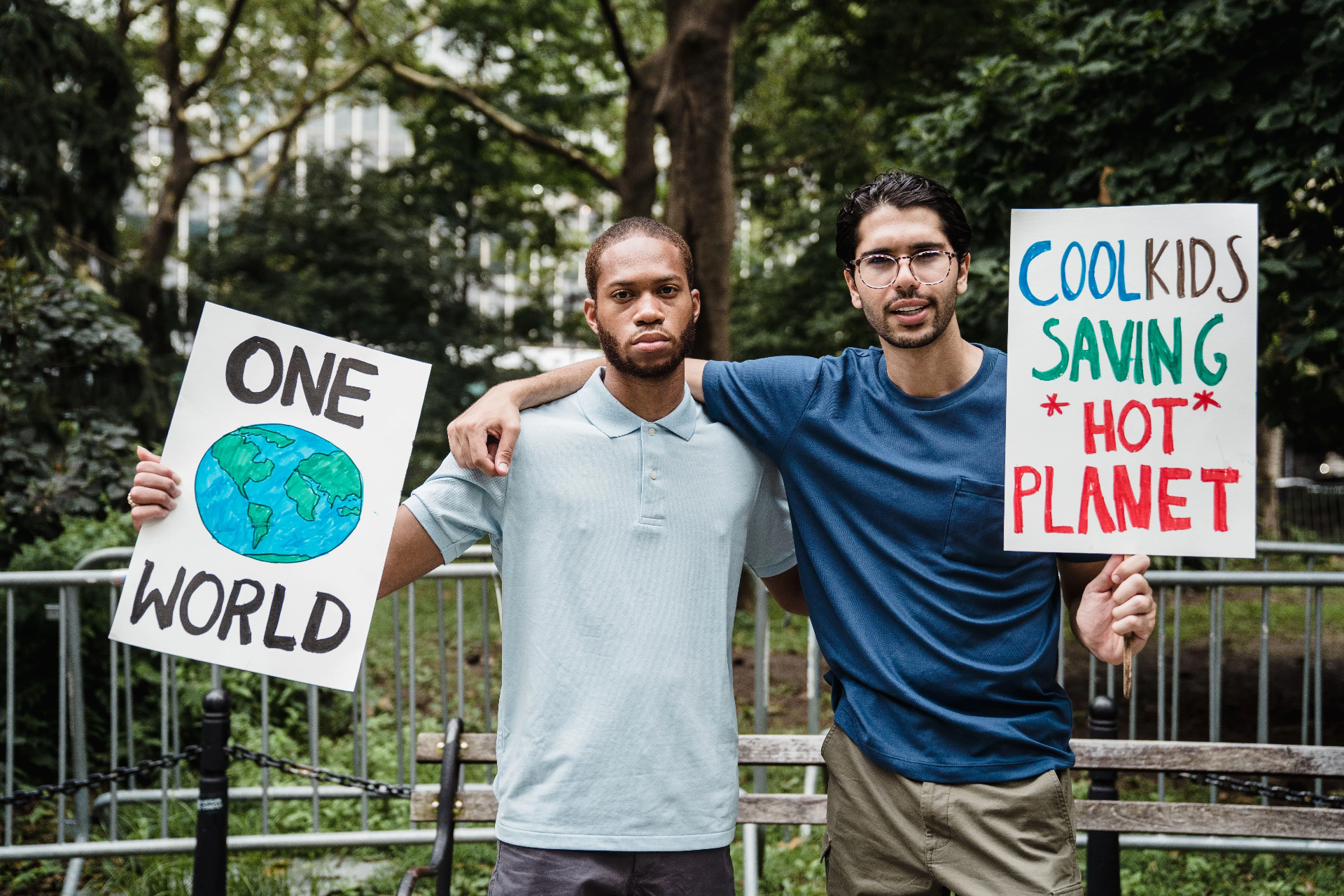 Two young activists holding climate placards in a public space