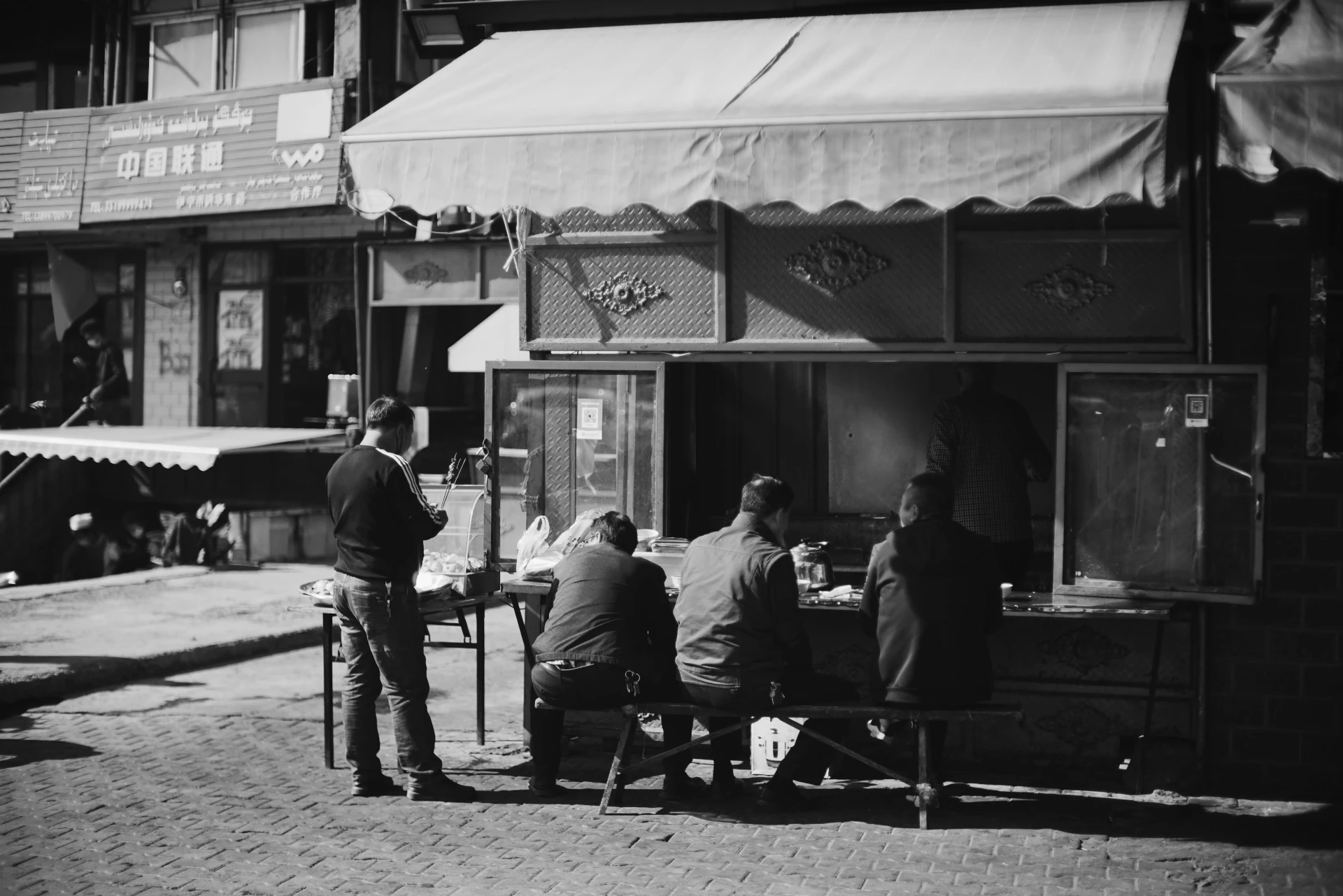 People eating together at a communal street-side table